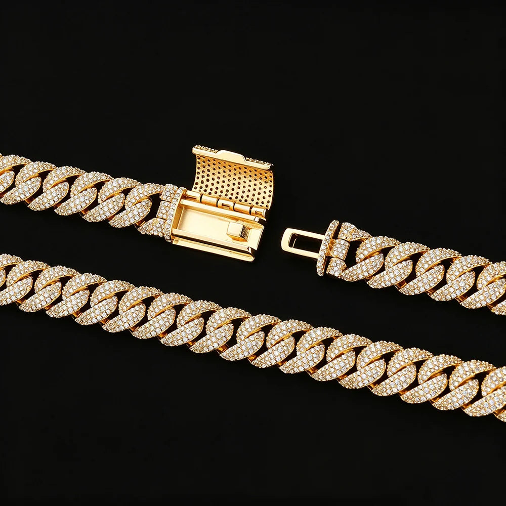 A gold-toned Cuban link chain bracelet paved with clear cubic zirconia stones, shown in two overlapping sections on a solid black background, highlighting the clasp and the detailed stone setting.