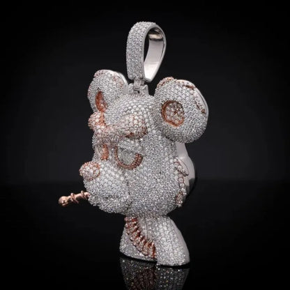 A highly detailed mouse-shaped pendant or charm covered in sparkling clear stones, with rose gold accents on the inner ears, eyes, mouth, and tail. The pendant is shown against a solid black background with a subtle reflection at the bottom.