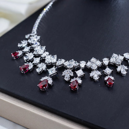 Jewelry set with red gemstones and silver accents on a dark surface