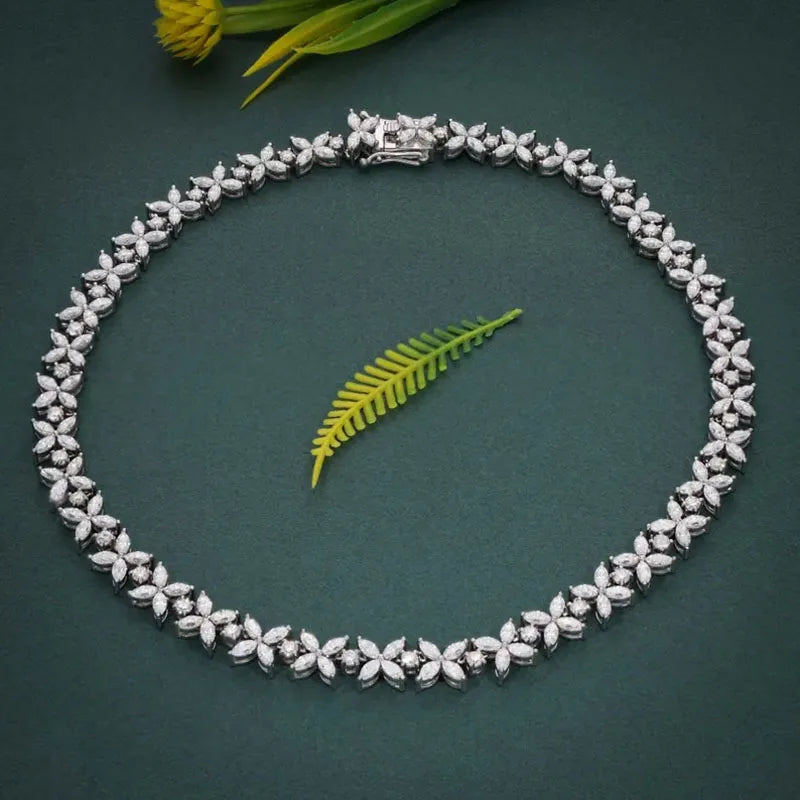 Silver necklace with floral design on a dark green background