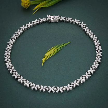 Silver necklace with floral design on a dark green background