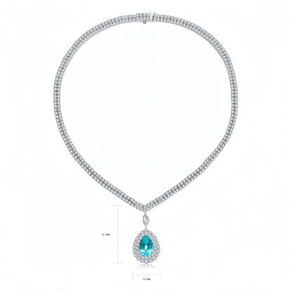 A silver-tone double-row diamond necklace with a teardrop-shaped pendant featuring a vibrant blue gemstone surrounded by small diamonds. The image includes dimension lines indicating a 25 mm height and 15 mm width.