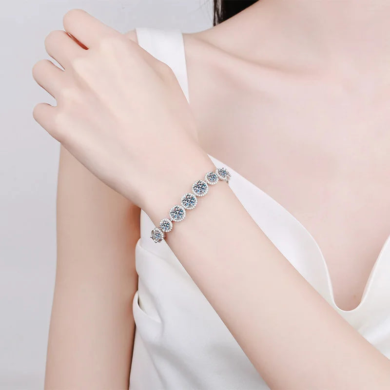 Silver bracelet on a person's wrist with a plain background