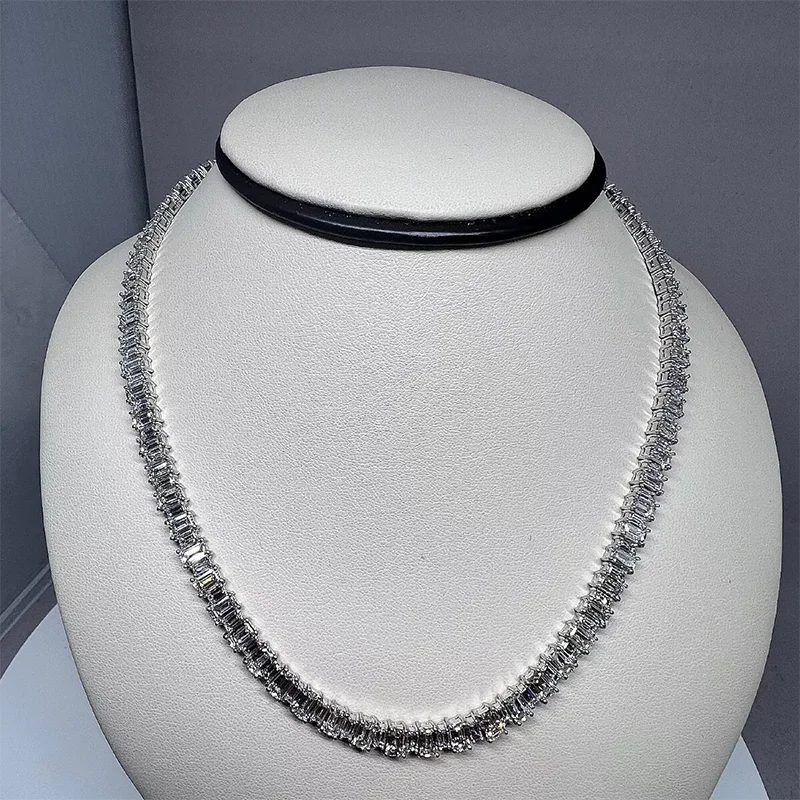 Silver necklace on a white mannequin bust against a gray background