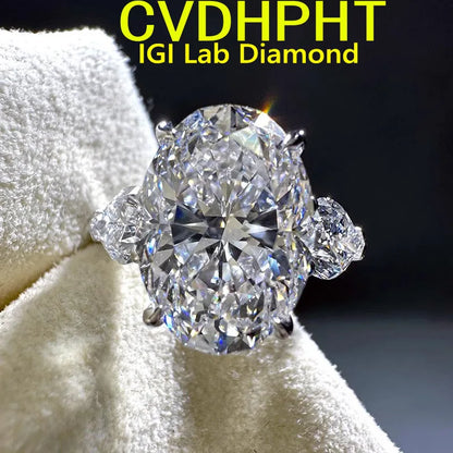 An oval-cut lab diamond ring with smaller side stones on a white velvet ring holder, with yellow text reading 'CVDHPHT IGI Lab Diamond' at the top against a dark background.