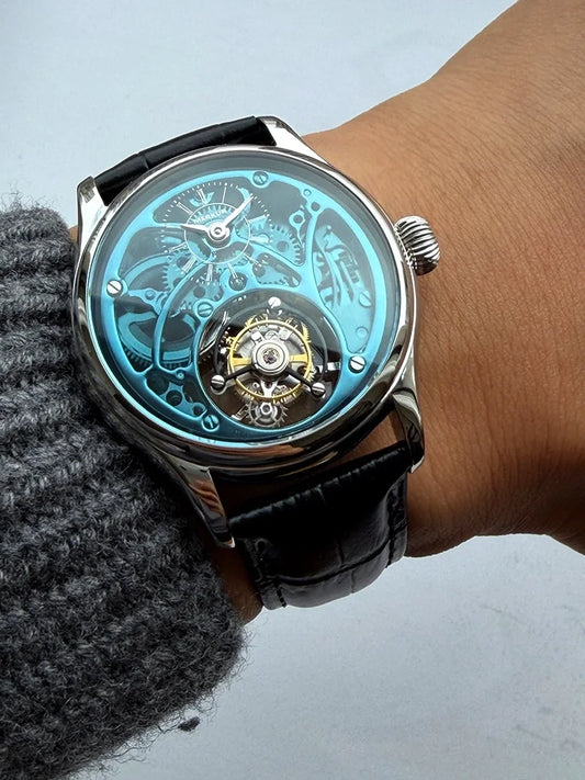 Close-up of a wrist wearing a black leather watch with a transparent face, showing mechanical components.
