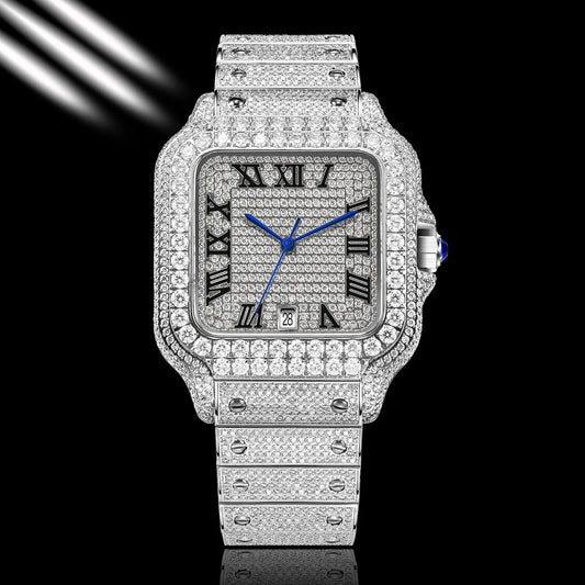 A luxury watch with a silver-toned square case and integrated bracelet, completely paved with sparkling clear stones. The dial is silver with black Roman numerals and vibrant blue hands, accented by a blue cabochon on the crown.